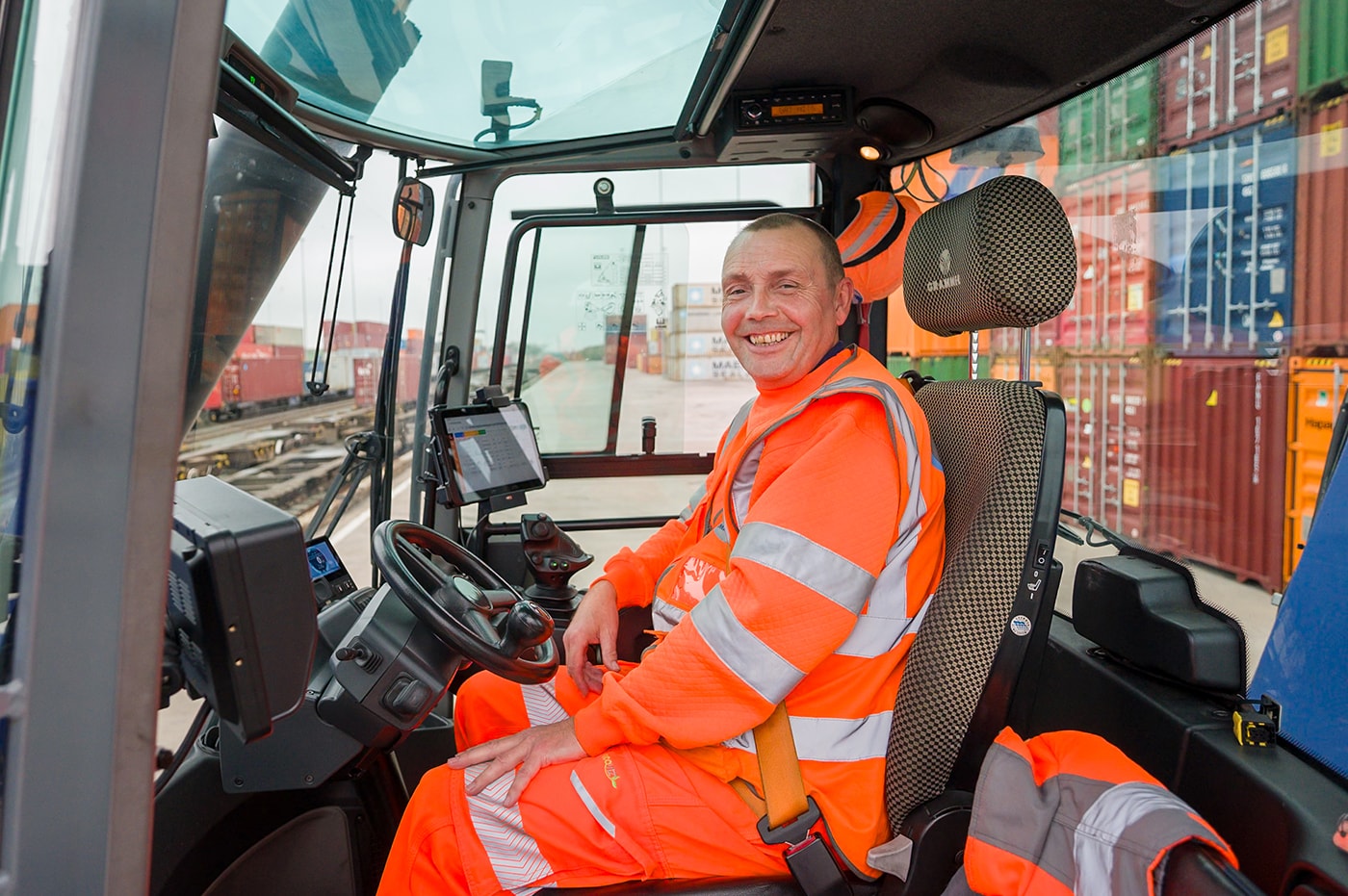 Man in high viz suit sitting in cab