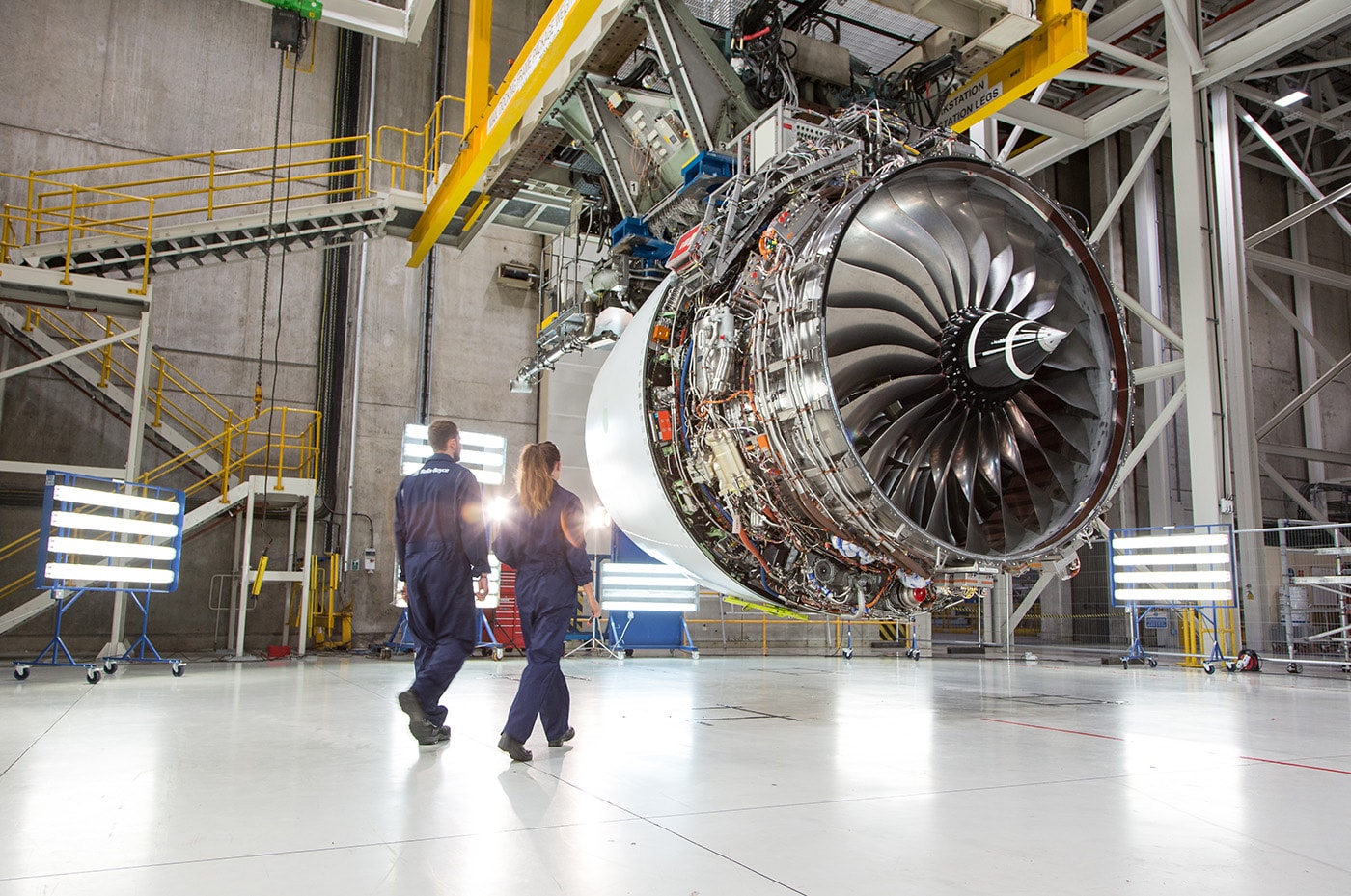 Two people walking towards aero engine