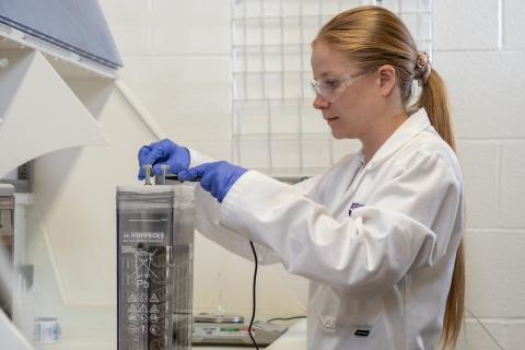 Person in lab coat battery electrolyser prototype testing